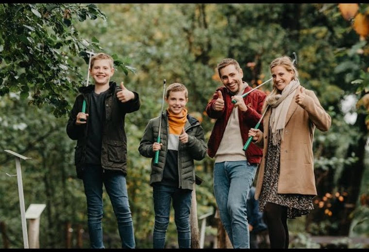 Familie beim Minigolf steht zusammen und freut sich über Schlag