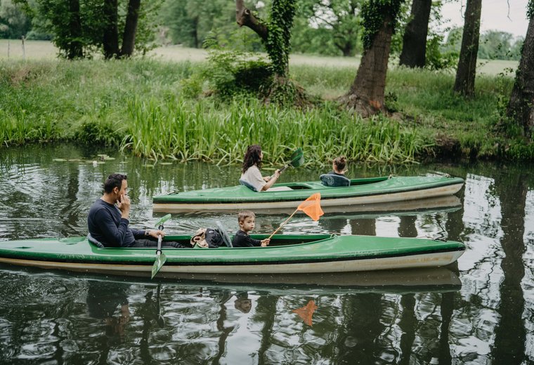 Familie paddelt mit 2 grünen Booten im Spreewald
