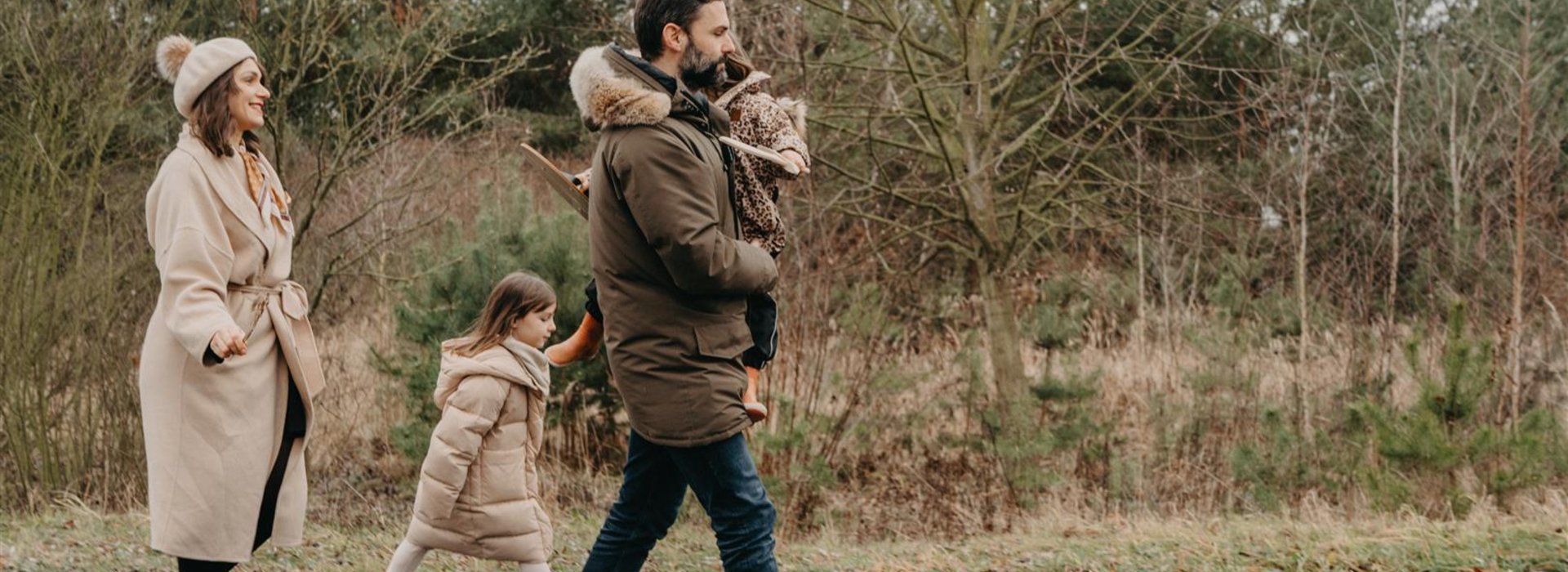 Familie läuft durch winterlichen Wald