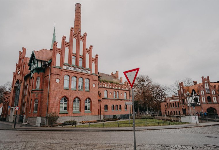 rotes Fachwerkhaus und Straßenschild im Vordergrund