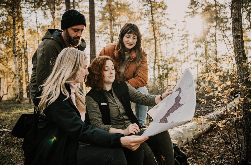 Gruppe in Wald schaut auf Karte
