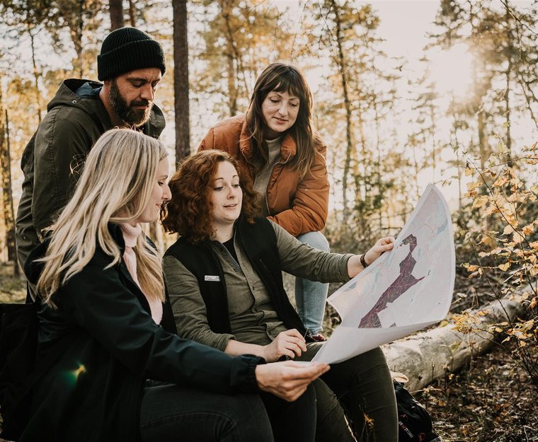 Gruppe in Wald schaut auf Karte