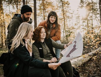 Gruppe in Wald schaut auf Karte