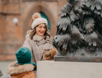Frau steht mit Kindern vor Statue in Cottbus