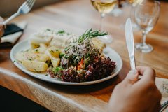 Mittagessen Nahansicht Teller mit Kartoffeln und Salat Hände die Besteck halten