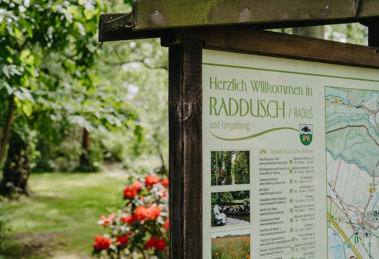 Teilansicht einer großen Karte im Spreewald und im Hintergrund Natur und rote Blumen