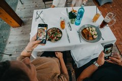 Mittagessen Szene zwei Teller stehen auf dem Tisch und mit dem Handy wird ein Foto von den Tellern gemacht
