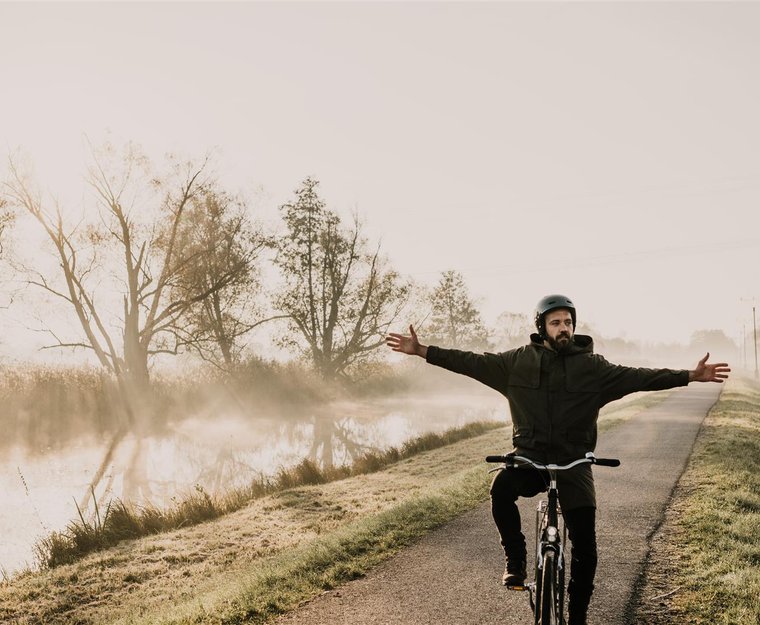 Mann fährt freihändig Fahrrad