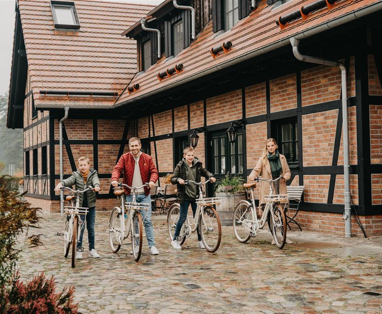 Familie auf Rädern vor alten Backhaus