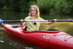 Screenshot von englischem Video über den Spreewald Frau paddelt in rotem Boot in Fließen
