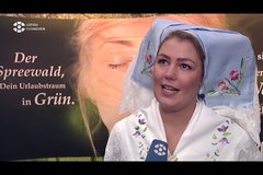Frau in klassischer Spreewaldtracht führt Interview auf Messe