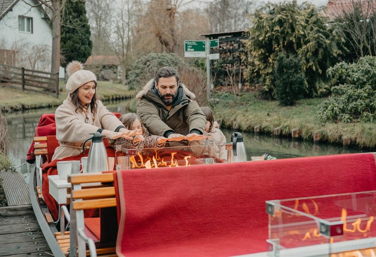 Familie bei Kahnfahrt mit Kamin im Winter im Spreewald