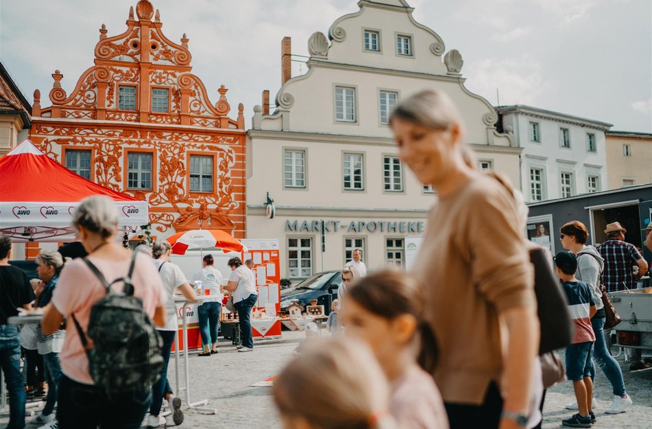 Stadtspiel Luckau Familie läuft durch Innenstadt hinten Fachwerkhäuser