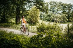 Frau fährt Rad durch Landschaft