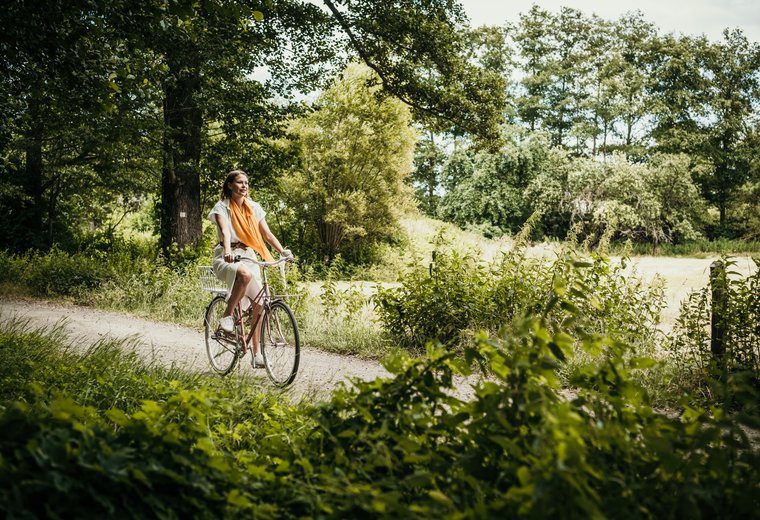 Frau fährt Rad durch Landschaft