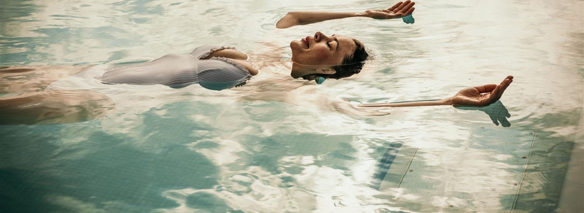 Frau schwimmt in Spreewald Therme im Wasser