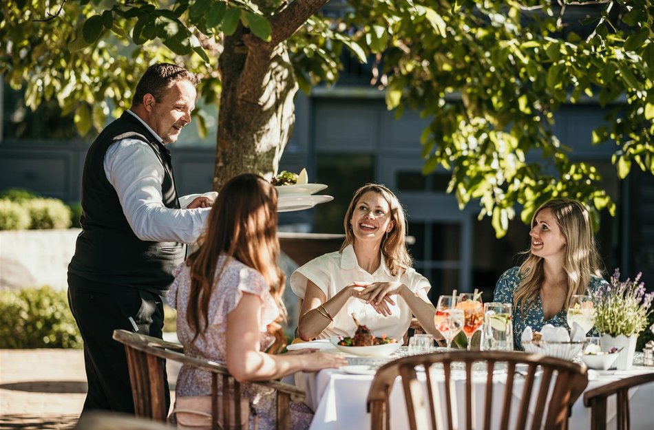 Frauen an Tisch Kellner bedient